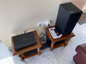 a room with two tables with a television and a speaker at Gîte du Jardin in Theux