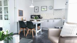 a kitchen and living room with a table and chairs at huisje Zilvermeeuw in Burgh Haamstede