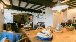 a dining room with a table and a living room at Hen Dafarn in Nefyn