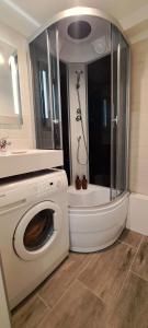 a washing machine in a bathroom with a shower at Lauku Str.Apartment in Liepāja +14 photos