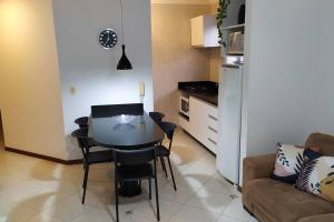 a kitchen with a table and chairs in a living room at Apartamento 102 do Residencial Argonauta in Bombinhas
