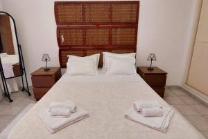 um quarto com uma cama grande e 2 toalhas em Moody & cozy 1br in city center em Luanda