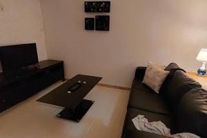 een woonkamer met een bank en een tafel bij Moody & cozy 1br in city center in Luanda