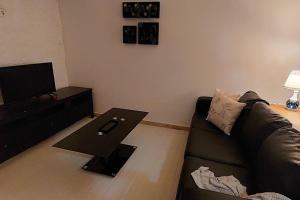 uma sala de estar com um sofá e uma mesa em Moody & cozy 1br in city center em Luanda