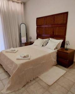 um quarto com uma cama grande com duas toalhas em Moody & cozy 1br in city center em Luanda