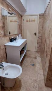 a bathroom with a sink and a toilet and a mirror at Moody & cozy 1br in city center in Luanda