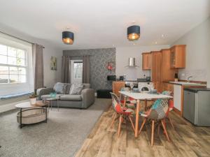 cocina y sala de estar con mesa y sillas en Buckland House Annex, en Taunton