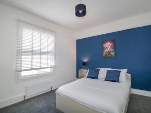 um quarto com uma cama grande e uma parede azul em Glenmore em Plymouth