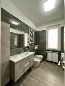 een badkamer met een wastafel, een toilet en een raam bij Villa 3 in Cassano dʼAdda