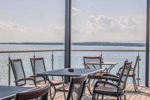 a balcony with tables and chairs and the water at Hotel Eurobus in Kaluža