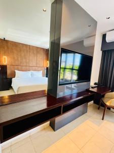 - une chambre avec un grand lit et une télévision dans l'établissement Lamana Hotel, à Port Moresby