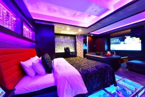 een slaapkamer met een groot bed en een televisie bij Hotel Vanilla Komaki (Adult Only) in Komaki