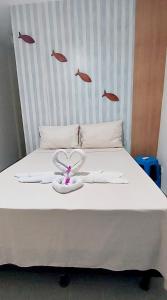 a bedroom with a bed with fish on the wall at Pousada Mandakaru in Maragogi