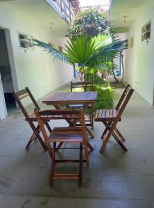 a wooden table and two chairs and a table and chairs at Pousada Mandakaru in Maragogi