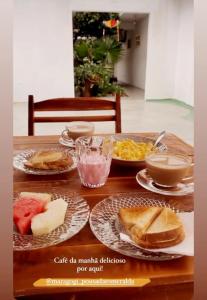 una mesa de madera con platos de comida. en Pousada Mandakaru, en Maragogi
