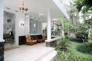 een veranda met een bank, stoelen en planten bij Kirana Guest House Bogor in Bogor
