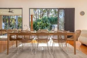 a dining room with a wooden table and chairs at Always Summer Boomerang in Boomerang Beach