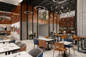 カサブランカにあるCourtyard by Marriott Casablanca Downtownのダイニングルーム(テーブル、椅子、テーブルトップ付)