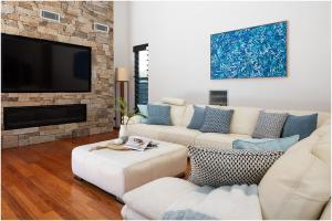 a living room with a couch and a tv at Always Summer Boomerang in Boomerang Beach