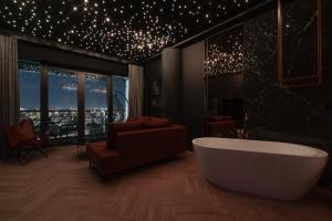 a bathroom with a tub and a living room with stars at Margi Velvet Apartament 13TH FLOOR LED CEILING BATH POOL in Szczecin