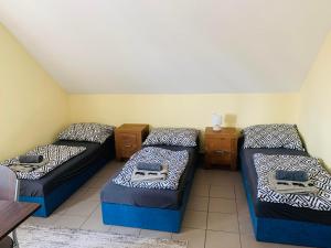 um quarto com três camas num quarto em Balaton Grill Szállás Siófok em Siófok