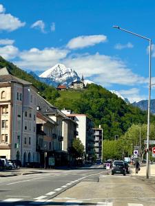a city street with a snow covered mountain in the background at Le Refuge T3 centre ville 63m2 pied des montagnes in Albertville