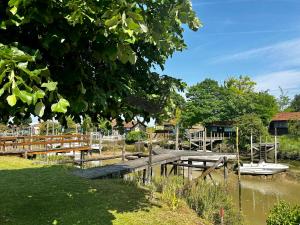 a wooden dock with a boat on the water at Ma Cabane - Agréable maison idéalement située in La Tremblade