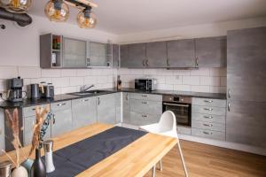 a kitchen with stainless steel appliances and a wooden table at Ferienwohnung zum Kunstei in Anger