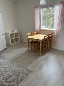 a kitchen with a table and chairs and a window at Apartment Kuokkamaantie, Pyhäjoki in Pyhäjoki