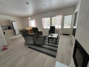 a living room with a couch and chairs and a tv at Apartment Kuokkamaantie, Pyhäjoki in Pyhäjoki