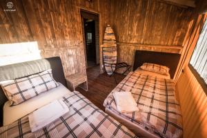 a bedroom with two beds in a wooden cabin at Oasis Camp Portugal in Lagoa