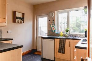 a kitchen with a sink and two windows at Ilford - Driveway- 3 bed- M6 J6 Contractors & Families in Birmingham