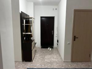 un pasillo con una puerta negra y un armario negro en 3 комнатная квартира, en Türkistan