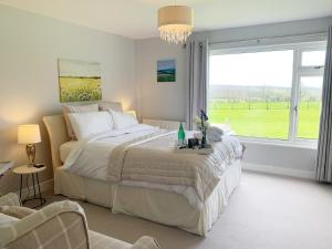 a bedroom with a large bed and a large window at Rowlands Annex in Yelverton