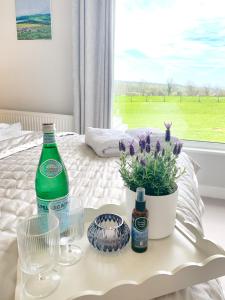einen Tisch mit einer Flasche und eine Topfpflanze auf einem Bett in der Unterkunft Rowlands Annex in Yelverton