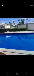 una gran piscina azul con palmeras en el fondo en Apartament litoral norte NatalRN en Natal