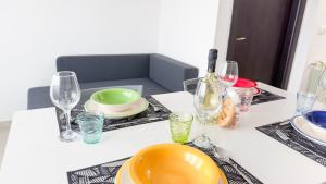 a table with plates and wine glasses on it at Esperia Apartment by Ca-Sa Check in Chioggia