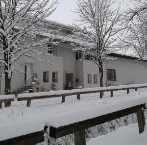 a snow covered house with trees and a fence at Ferienwohnung Lahnbachallee, Schwaz in Schwaz