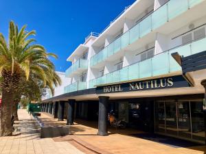 un hotel con una palmera delante en Nautilus Hotel en Rosas