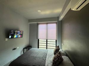 a bedroom with a large bed and a window at Icónica Torre K Departamento by AIRA in Villahermosa