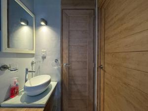 a bathroom with a sink and a wooden door at Icónica Torre K Departamento by AIRA in Villahermosa