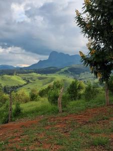 a view of a field with mountains in the background at Pousada Pico do Papagaio in Aiuruoca