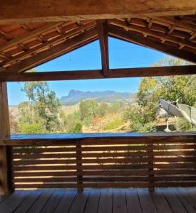 a view from a deck with a view of the mountains at Pousada Pico do Papagaio in Aiuruoca