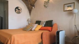1 dormitorio con 1 cama con manta naranja en Merli e Merletti - affittacamere- monolocale luminoso e indipendente nel cuore di Offida, en Offida