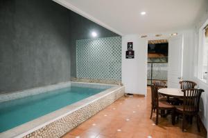 a swimming pool with a table and chairs and a table and a tablektop at Kirana Guest House Bogor in Bogor