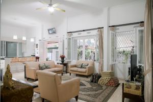 a living room with a couch and chairs and a tv at Kirana Guest House Bogor in Bogor