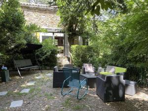 grupa krzeseł i stół na dziedzińcu w obiekcie L'Oustalet du Cagnel w mieście Valleraugue