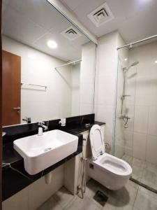Un baño con lavabo, inodoro y espejo. en LikeHome - Amazing 2 BR With Burj Khalifa & Canal View, en Dubái