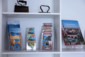 a book shelf with books and magazines at Boutique Apartment Cà Monastero in Verona