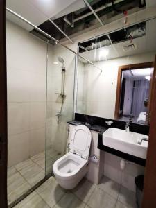 Un baño con inodoro, lavabo y ducha. en LikeHome - Amazing 2 BR With Burj Khalifa & Canal View, en Dubái 18 fotos más